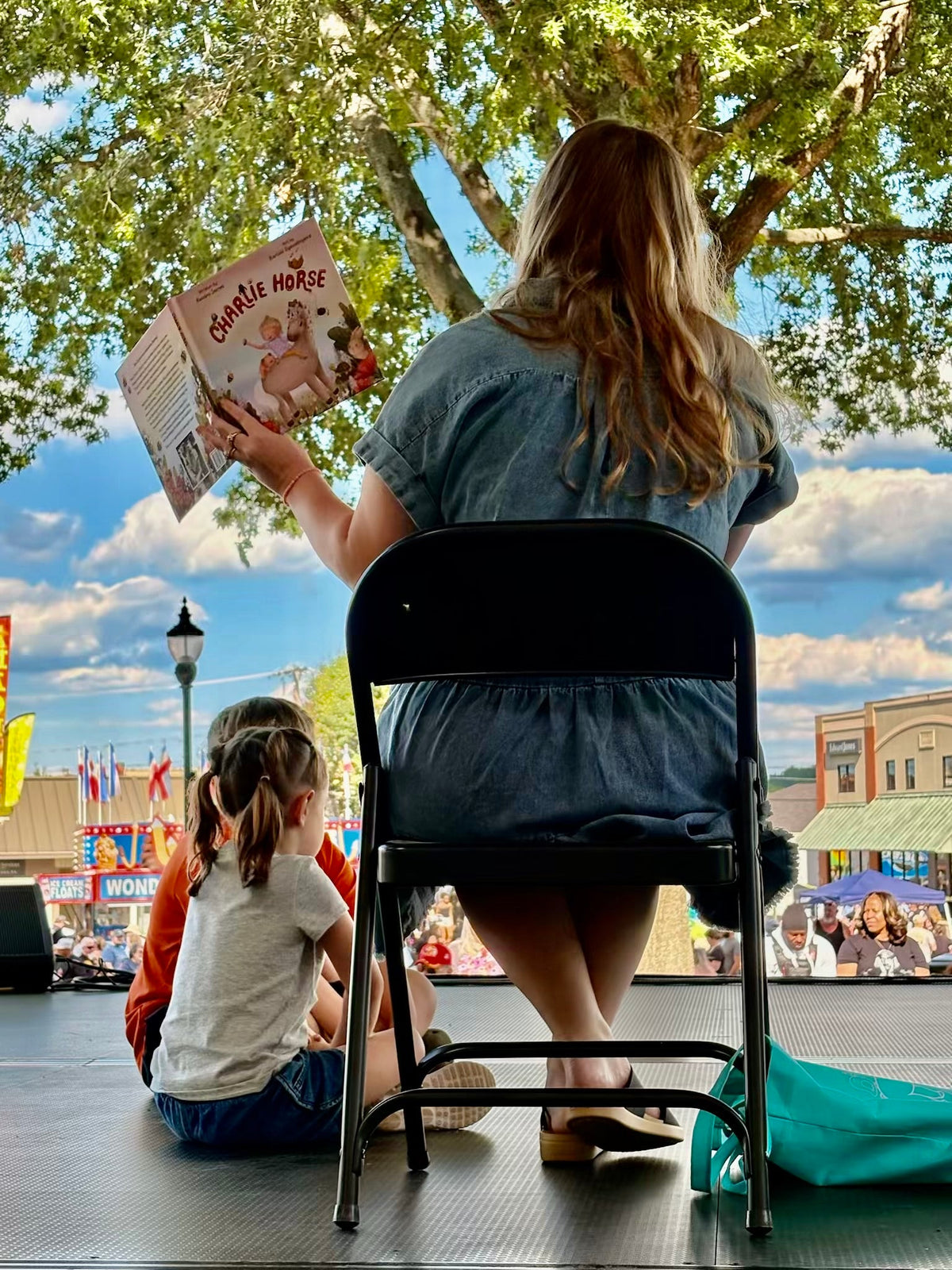 Author Kendra James reading Charlie Horse to children during an outdoor storytime event