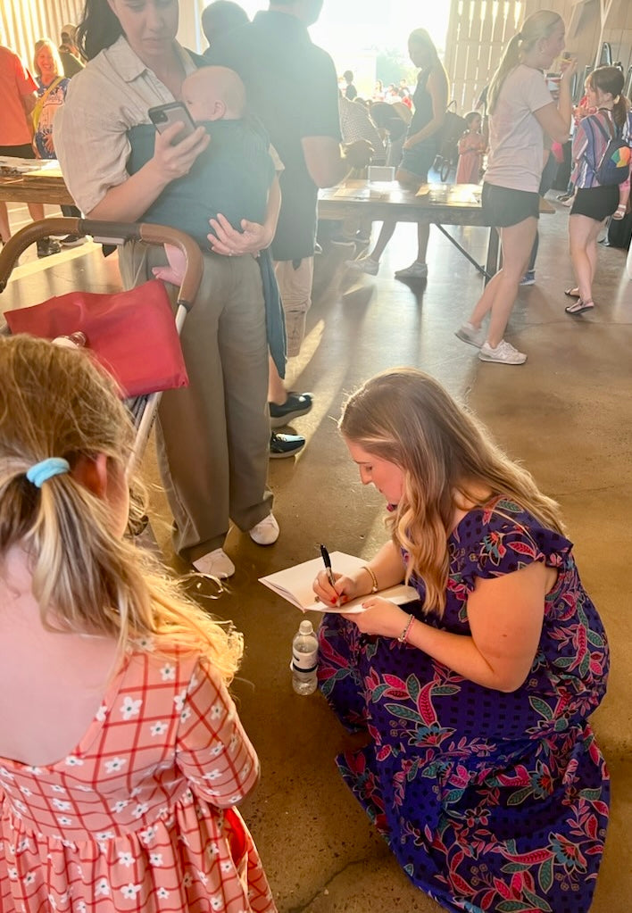 Kendra James signing a personal copy of Charlie Horse for a young reader